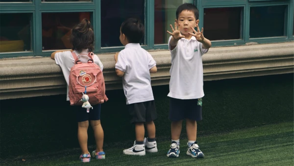three young students outside window of international school of wuxi early childhood center