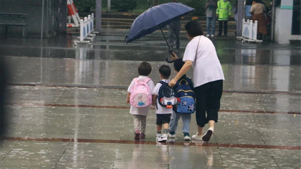 teacher keeping international school of wuxi safety for students in the rain