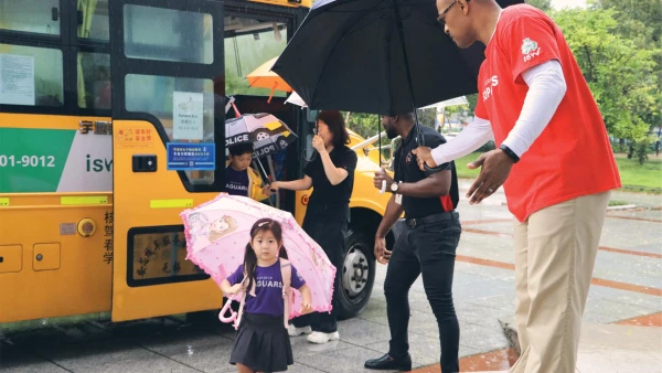 young female student at international school of wuxi learning to walk with her pink umbrella