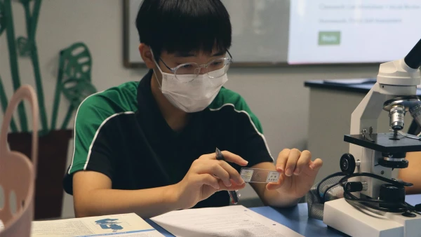 male student conducting an international school of wuxi high school science experiment