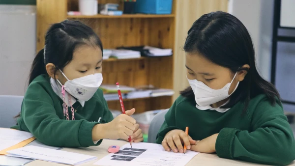 international school of wuxi elementary children working together on their schoolwork