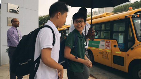 two male students at international school of wuxi learning from each other as they leave class